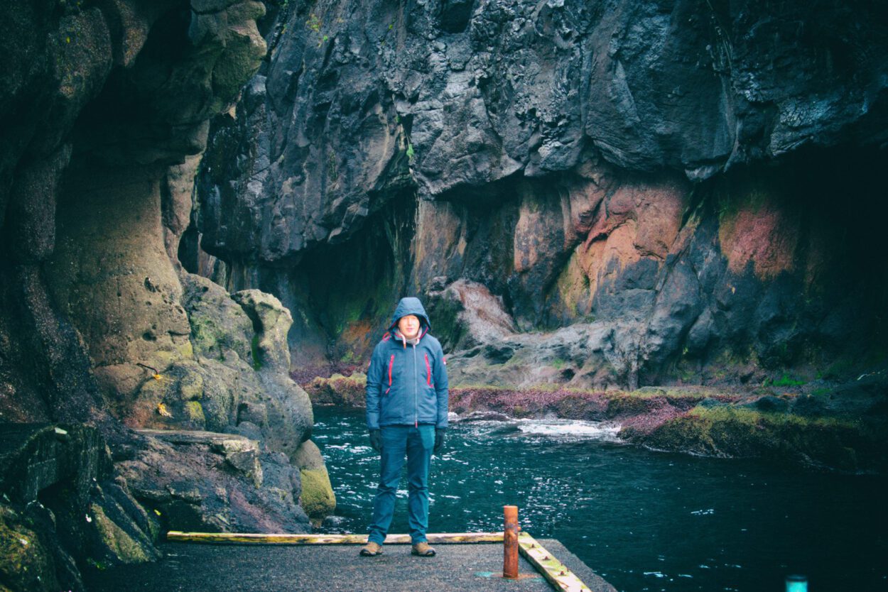 Ein Mann steht vor einer Höhle.