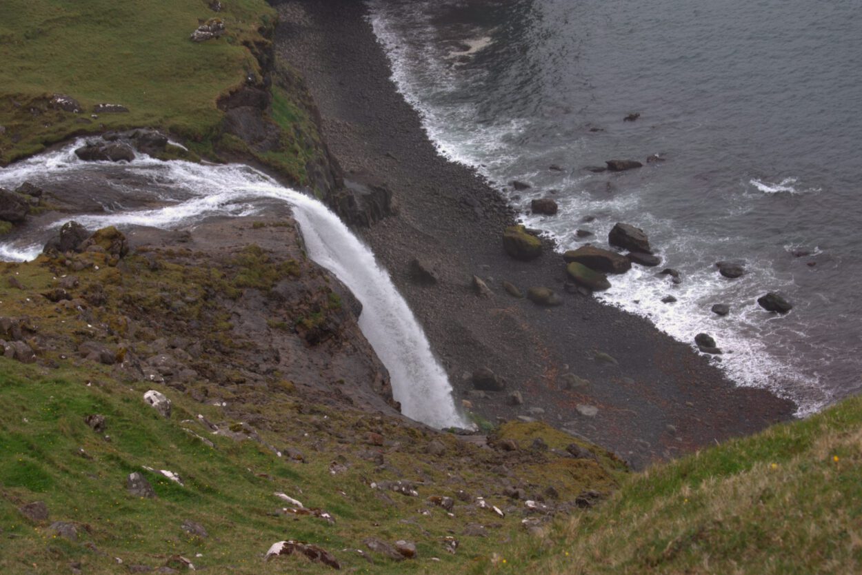 Ein Wasserfall an einer Klippe in der Nähe des Ozeans.