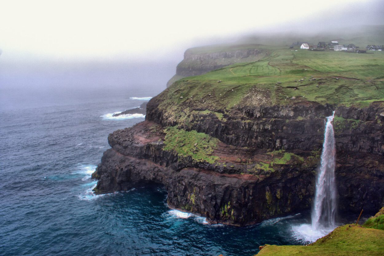 Ein Wasserfall auf einer Klippe mit Blick auf den Ozean.