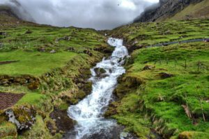 Ein Wasserfall inmitten eines üppig grünen Tals.