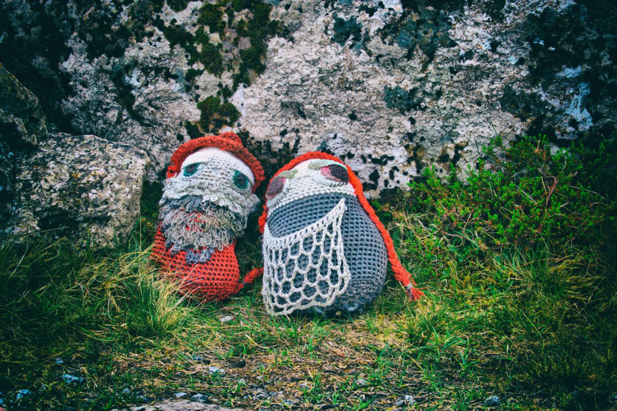 Ein Paar gehäkelte Schuhe, die auf einem Felsen sitzen.