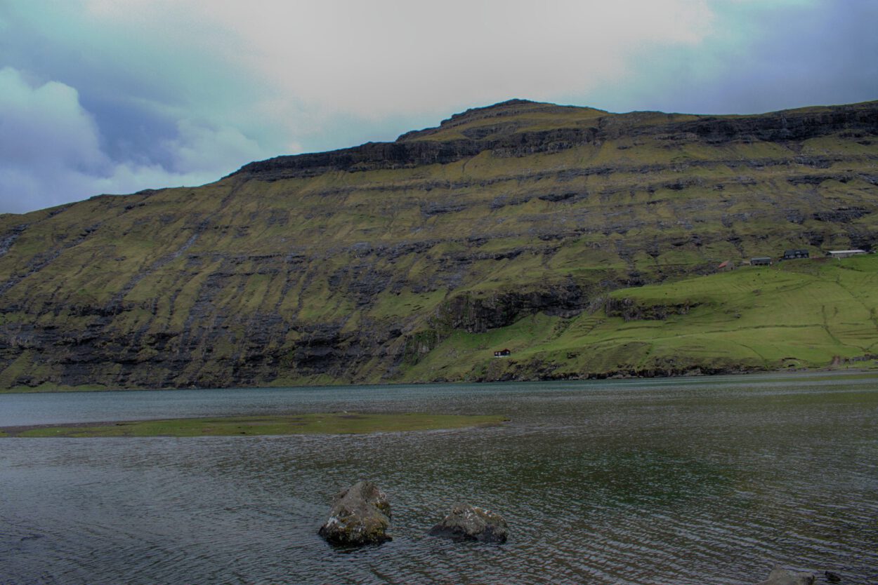 Ein großes Gewässer mit einem Berg im Hintergrund.
