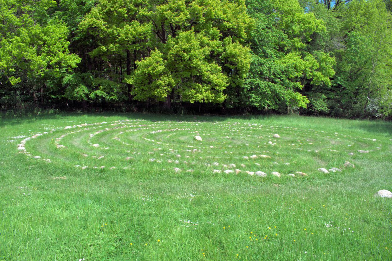 Ein kreisförmiges Labyrinth inmitten einer Wiese.