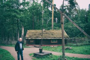 Ein Mann steht vor einer Holzhütte im Wald.