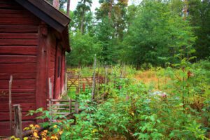 Ein rotes Haus mit einem Garten im Hintergrund.