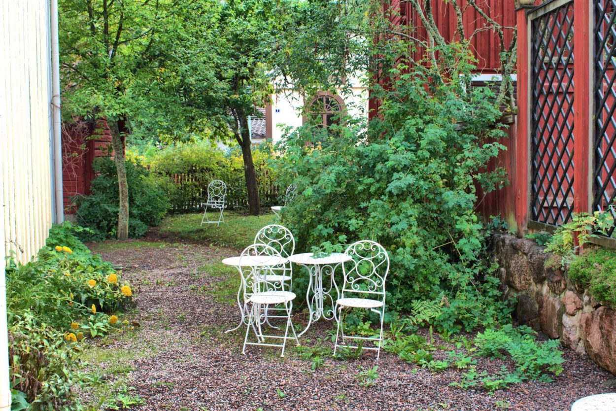 Ein weißer Tisch und Stühle in einem Garten.