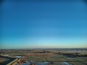 Ein Flugzeug fliegt über ein Feld.