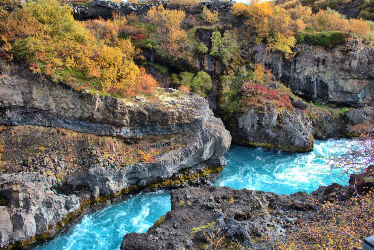 Ein blauer Fluss, der durch ein felsiges Gebiet fließt.