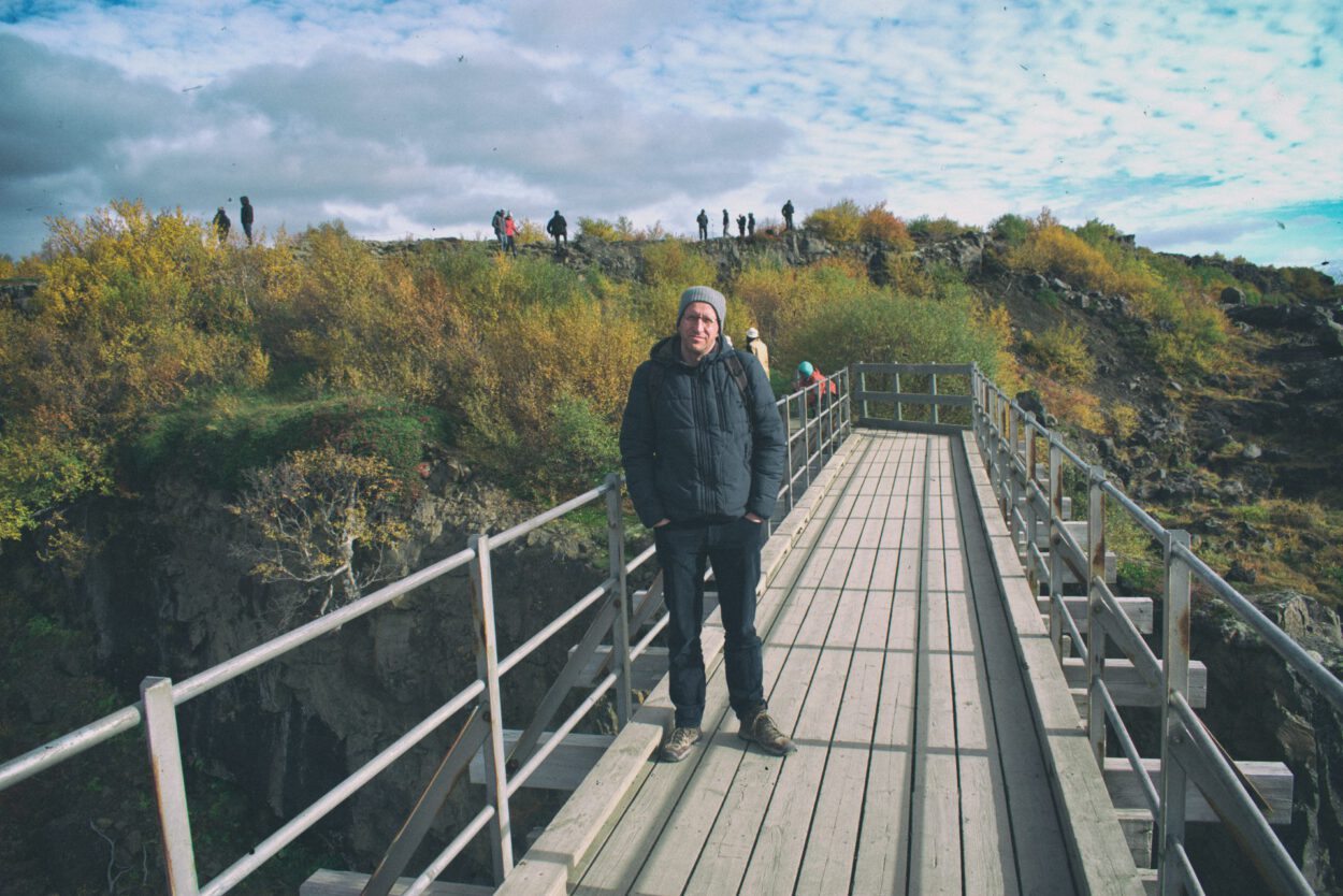Ein Mann steht auf einer Brücke über einer Klippe.