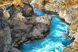 Ein blauer Fluss, der durch ein felsiges Gebiet fließt.