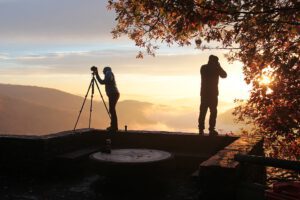 Zwei Personen fotografieren bei Sonnenuntergang.