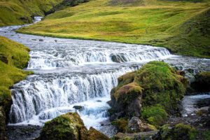 Ein Wasserfall inmitten eines üppig grünen Tals.