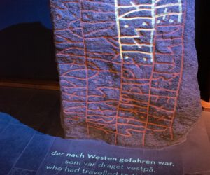 In einem Museum ist ein Stein mit Schriftzug ausgestellt.