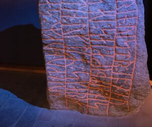 In einem Museum ist ein Stein mit Schriftzug ausgestellt.
