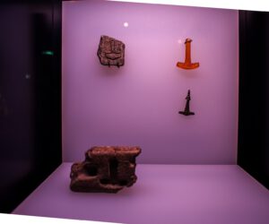 Eine Vitrine mit einem Stein und einem Hammer.