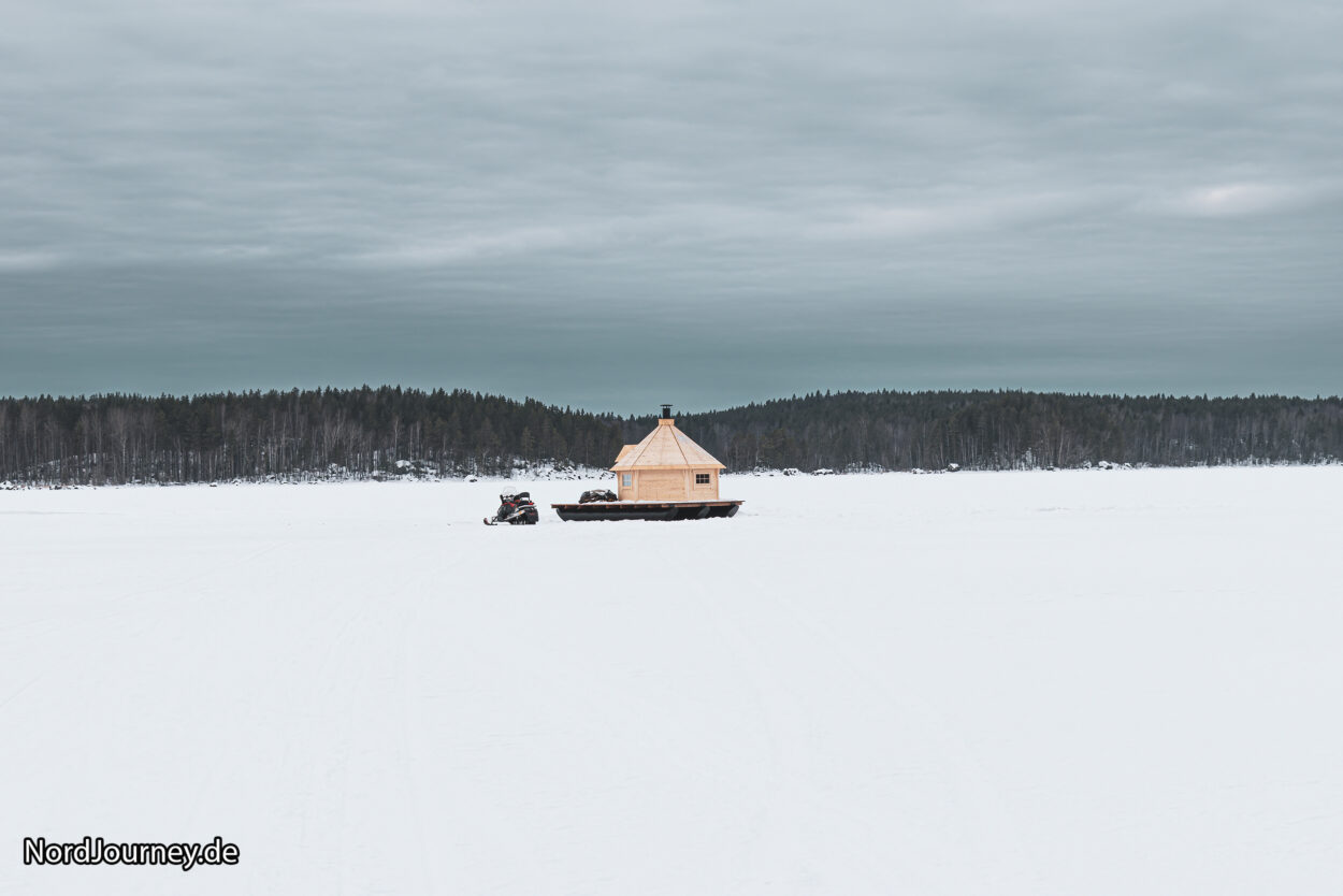 Eine kleine Hütte mitten auf einem verschneiten Feld.