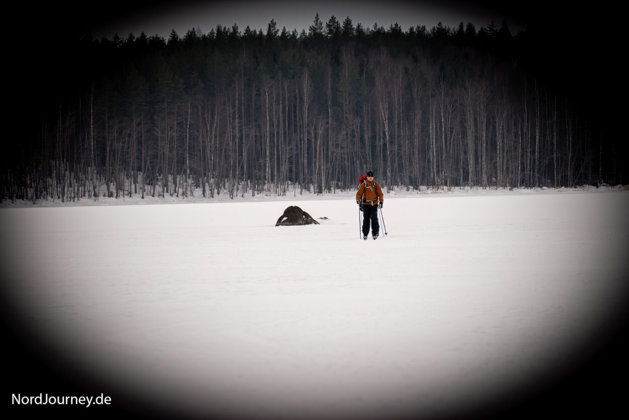 Eine Person steht auf einem schneebedeckten Feld.