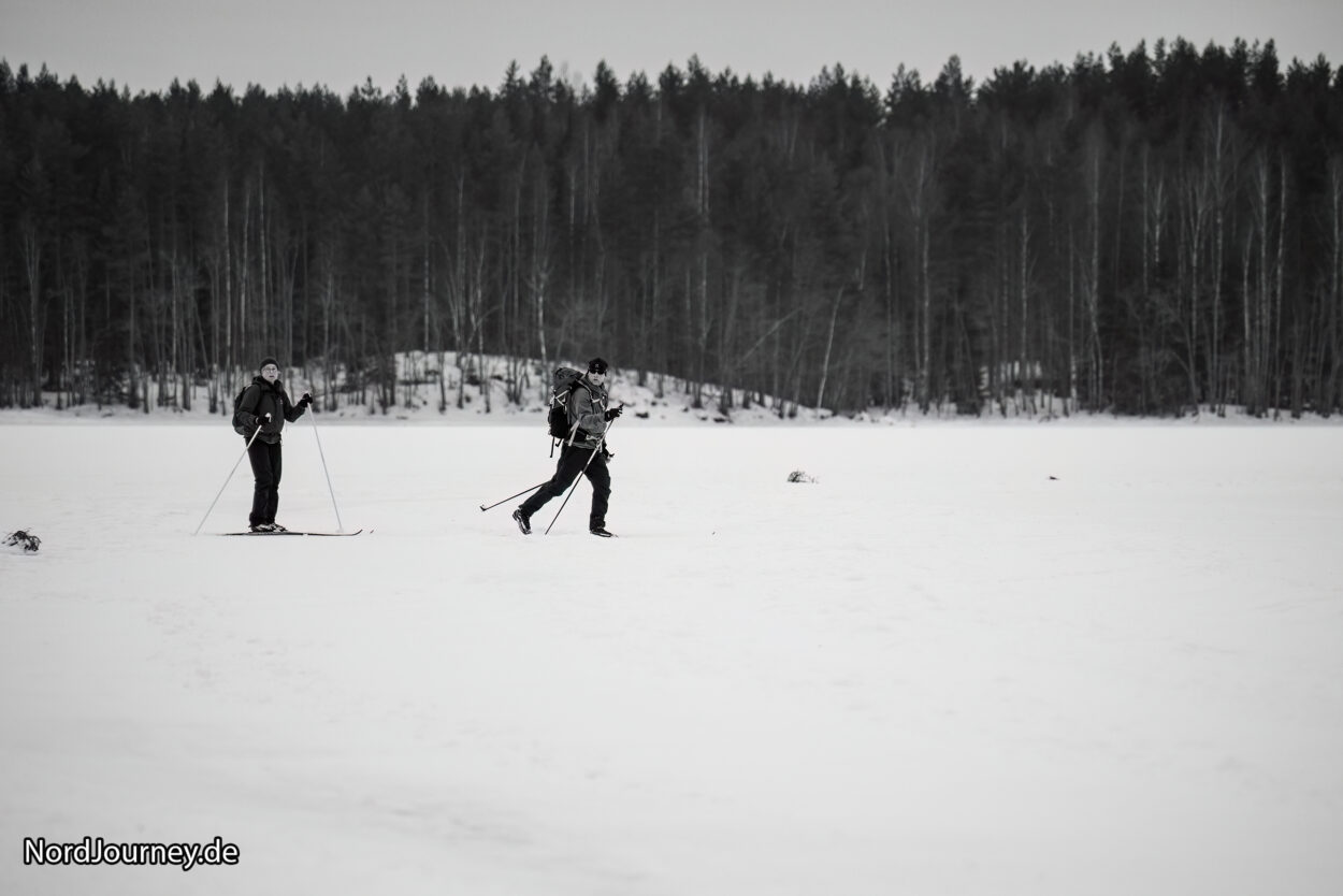 Zwei Personen fahren Langlauf im Schnee.