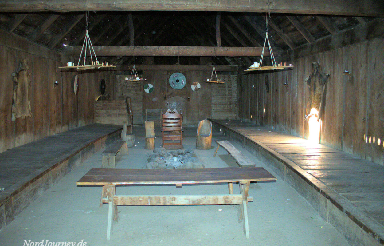 Ein Holzzimmer mit Bänken und einem Kamin.