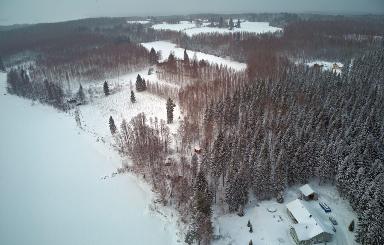 Eine Luftaufnahme eines schneebedeckten Feldes und eines Hauses.