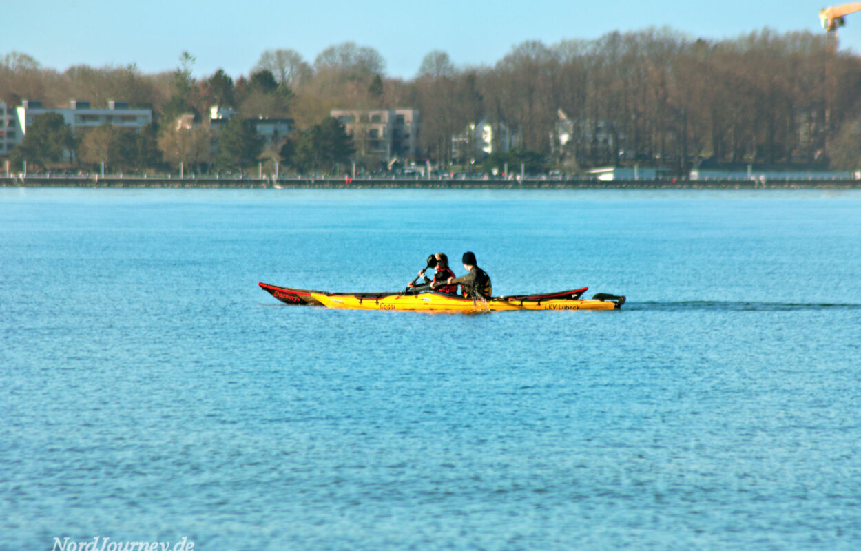 Zwei Personen in einem gelben Kanu auf einem Gewässer.