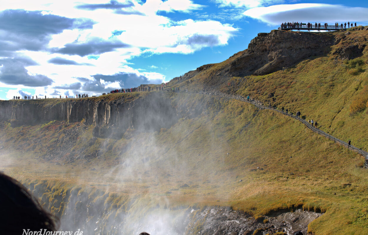 Eine Gruppe von Menschen steht in der Nähe eines Wasserfalls.
