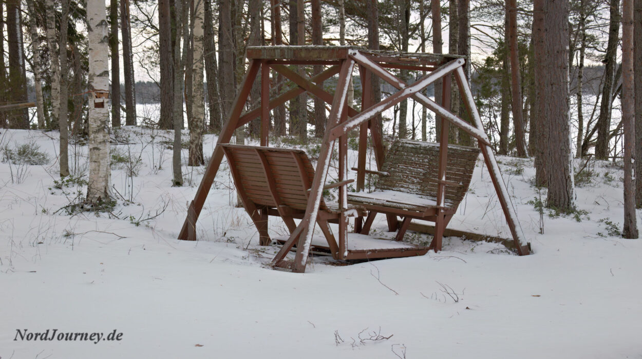 Eine Holzschaukel im Schnee.