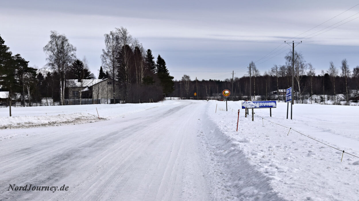 Eine Straße im Schnee mit einem Schild in der Mitte.