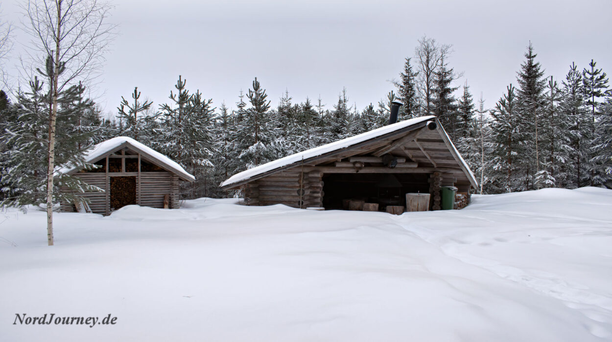 Zwei Holzhütten im Schnee.