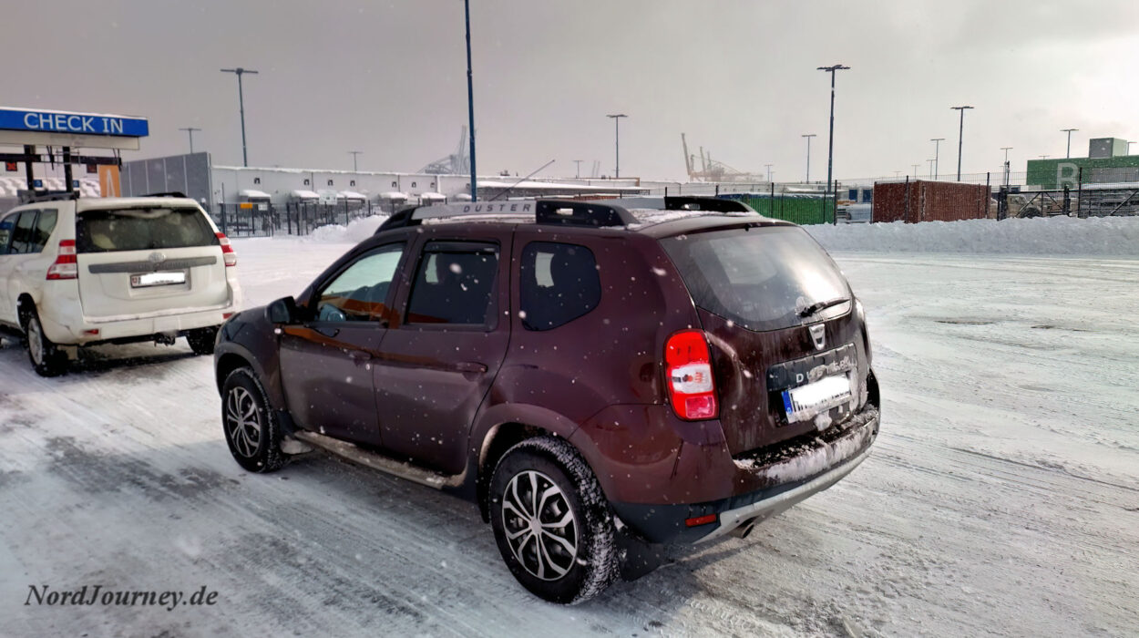 Ein brauner SUV parkt im Schnee.